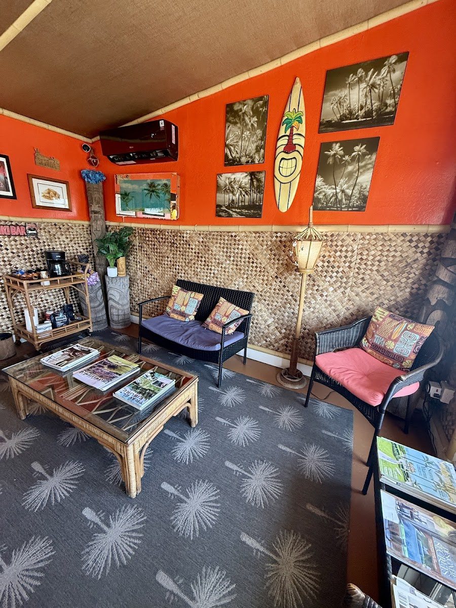 The orange Smog Oasis waiting lounge with sofas, surfboard art and a coffee table